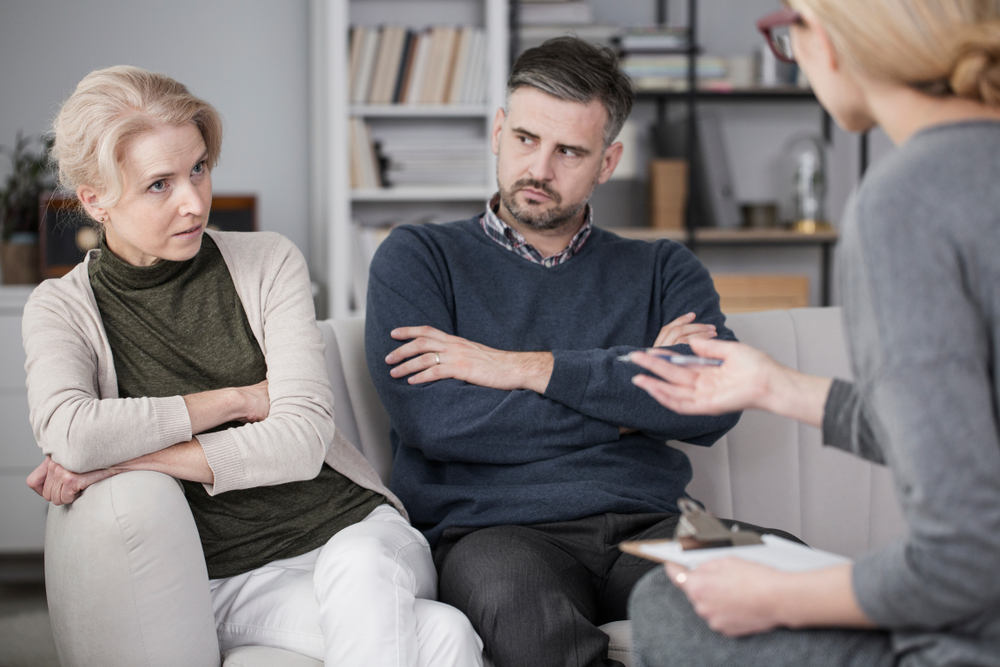stock photo tired woman talking to a mediator about her bad relationships with her husband who is quarrelsome 1017742096