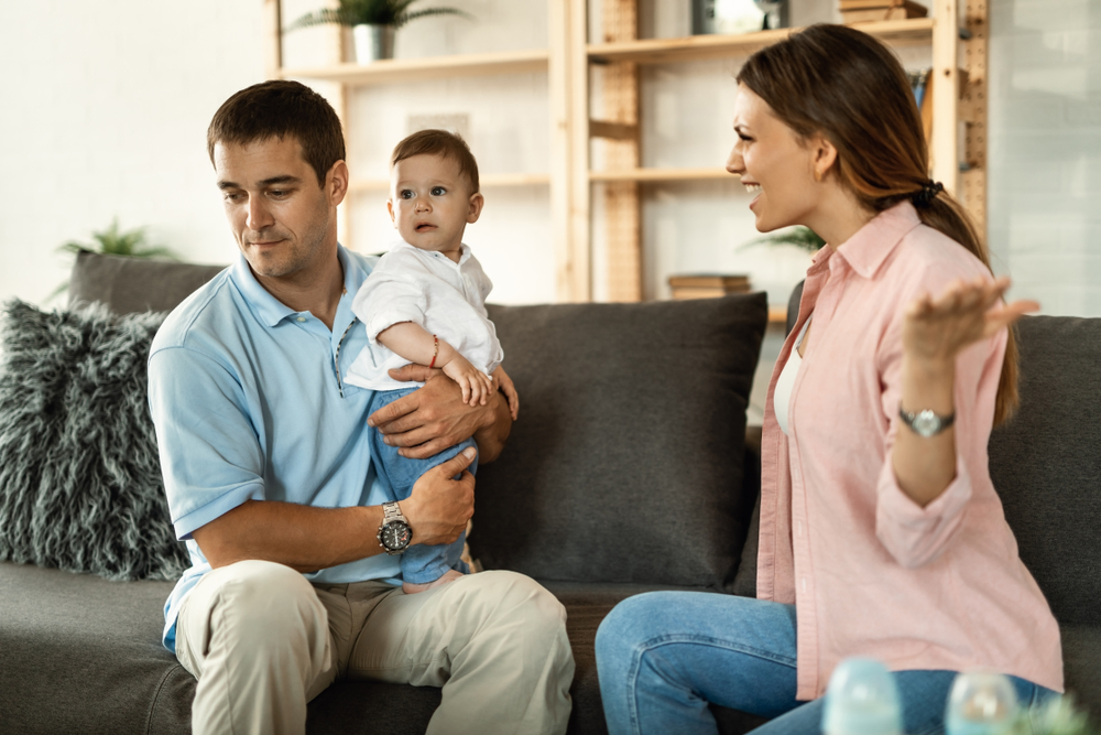stock photo happy kid sitting on his father s lap next to his mother during a meeting with school counselor 1092550253
